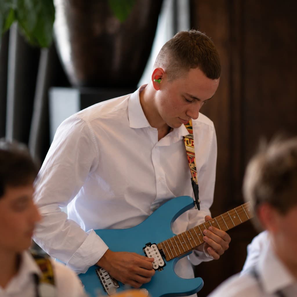 Ewan Ellson playing guitar, co-founder of ESAT Camp